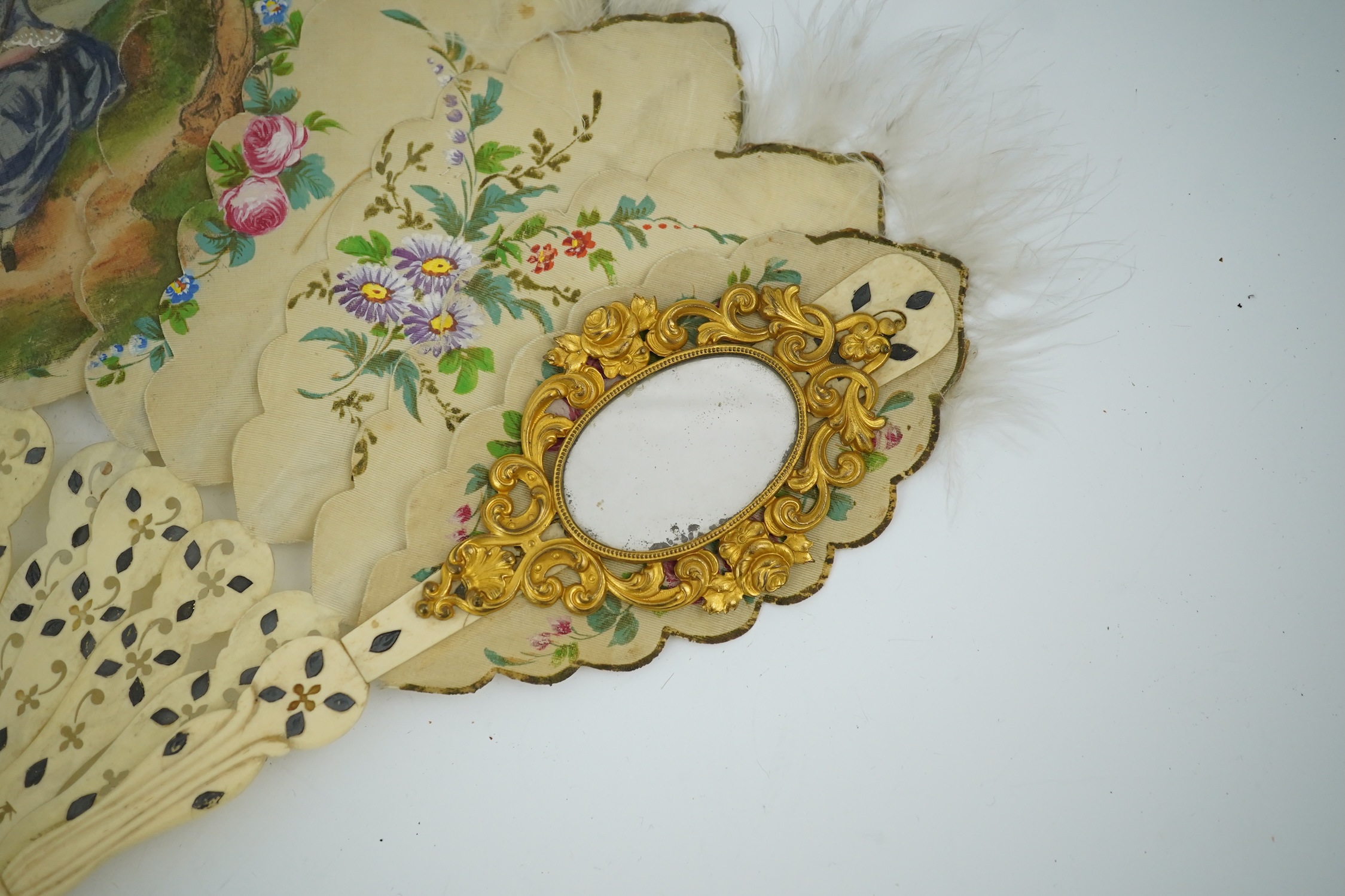 Three French fans: a mother of pearl and sequin fan boxed, a painted silk, feather and bone fan and a gilt decorated bone figural paper fan, the two bone fans having gilt mirrored mounts on the guards, figural paper fan